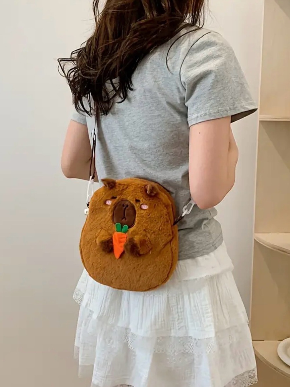New Cappabara bag with strap holding a carrot cut fuzzy purse bag